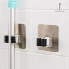 Wall mounted broom holder holding broom and mop